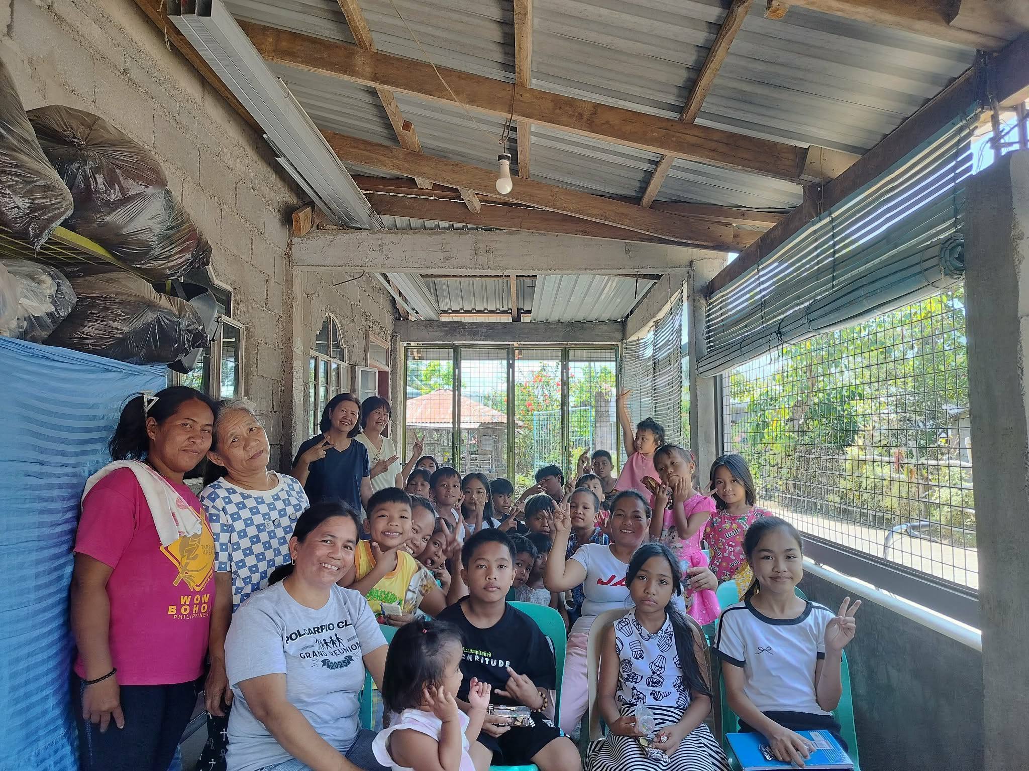 Children, mothers, and grandmothers gathered together indoors