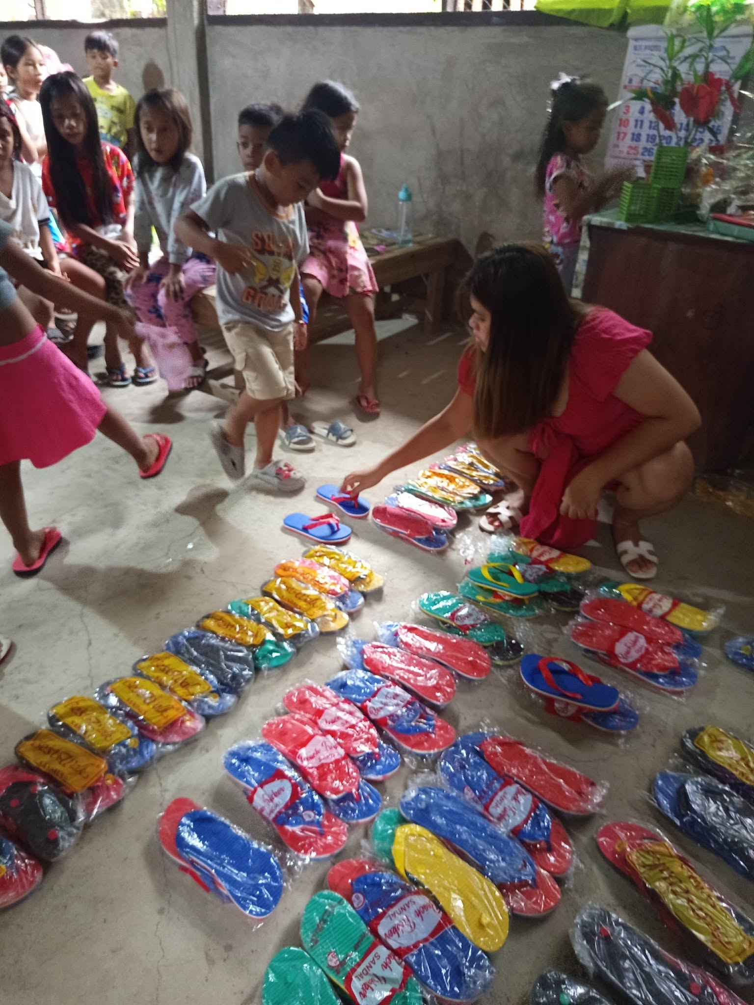 A volunteer laying out new slippers for children to choose from