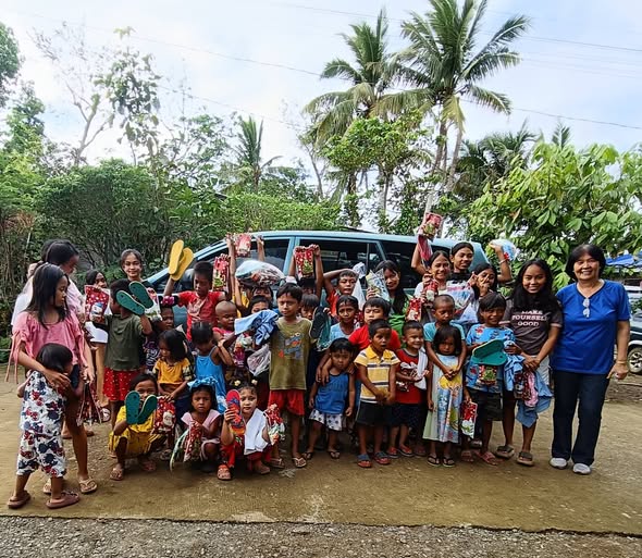 Children holding new slippers and gifts outdoors